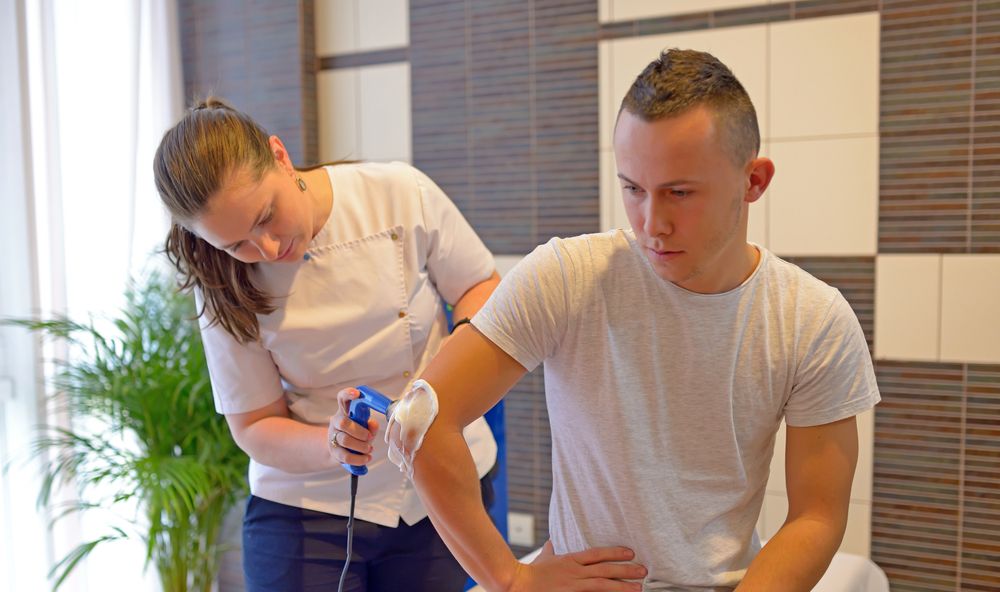 man getting ultrasound from female physiotherapist