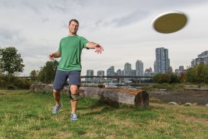 man throwing frisbee in knee brace